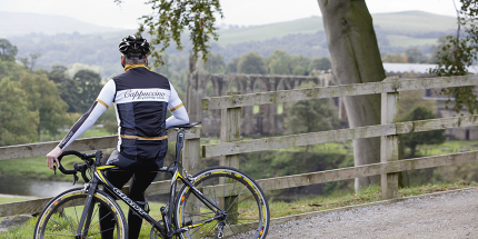 A cyclist looks over the Bolton Abbey ruins