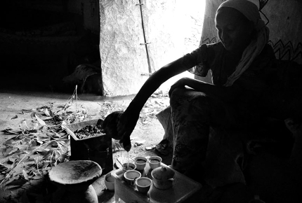 A woman fills cups at Ethiopian coffee ceremony