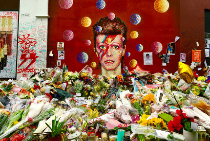 Flowers pile up outside the Bowie mural in Brixton