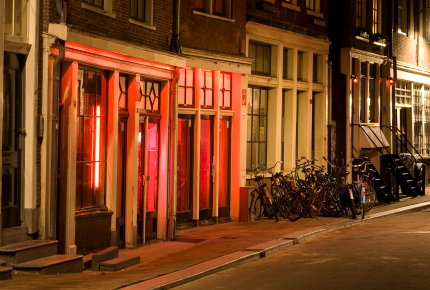 Red lights illuminate the streets of Amsterdam