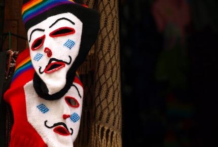 Waq'ollo masks hang in a Peruvian market