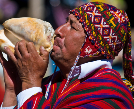 A man blows a shell at Peru's Qoyllur Rit’I