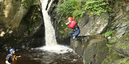 A gorge walker leaps into a plunge pool