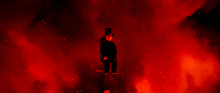 A lonesome Guy sits atop the town's giant bonfire