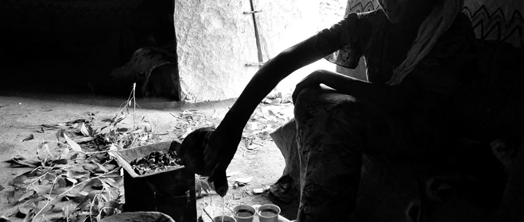 A woman fills cups at Ethiopian coffee ceremony