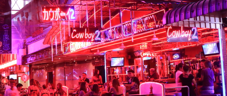 Girls wait outside one of Patpong's dazzling neon-lit bars