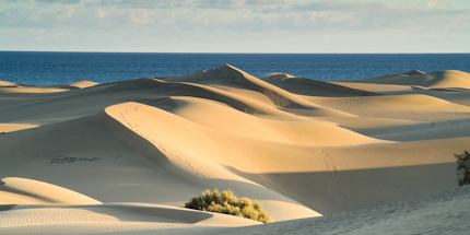 The sunset casts shadows on the dunes of Gran Canaria