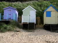 Pretty beach huts decorate the coast