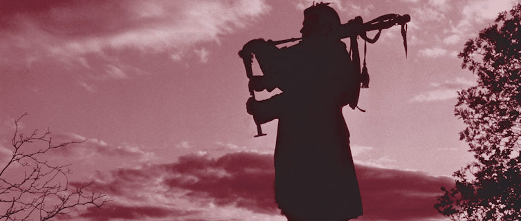 Scottish Highlander playing bagpipes