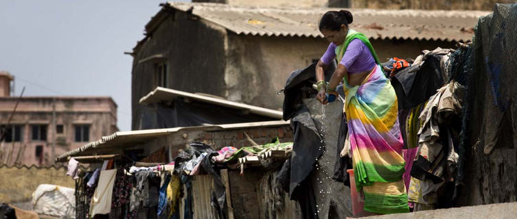 Woman doing the laundry and setting it out to dry in the sun in Mumbai
