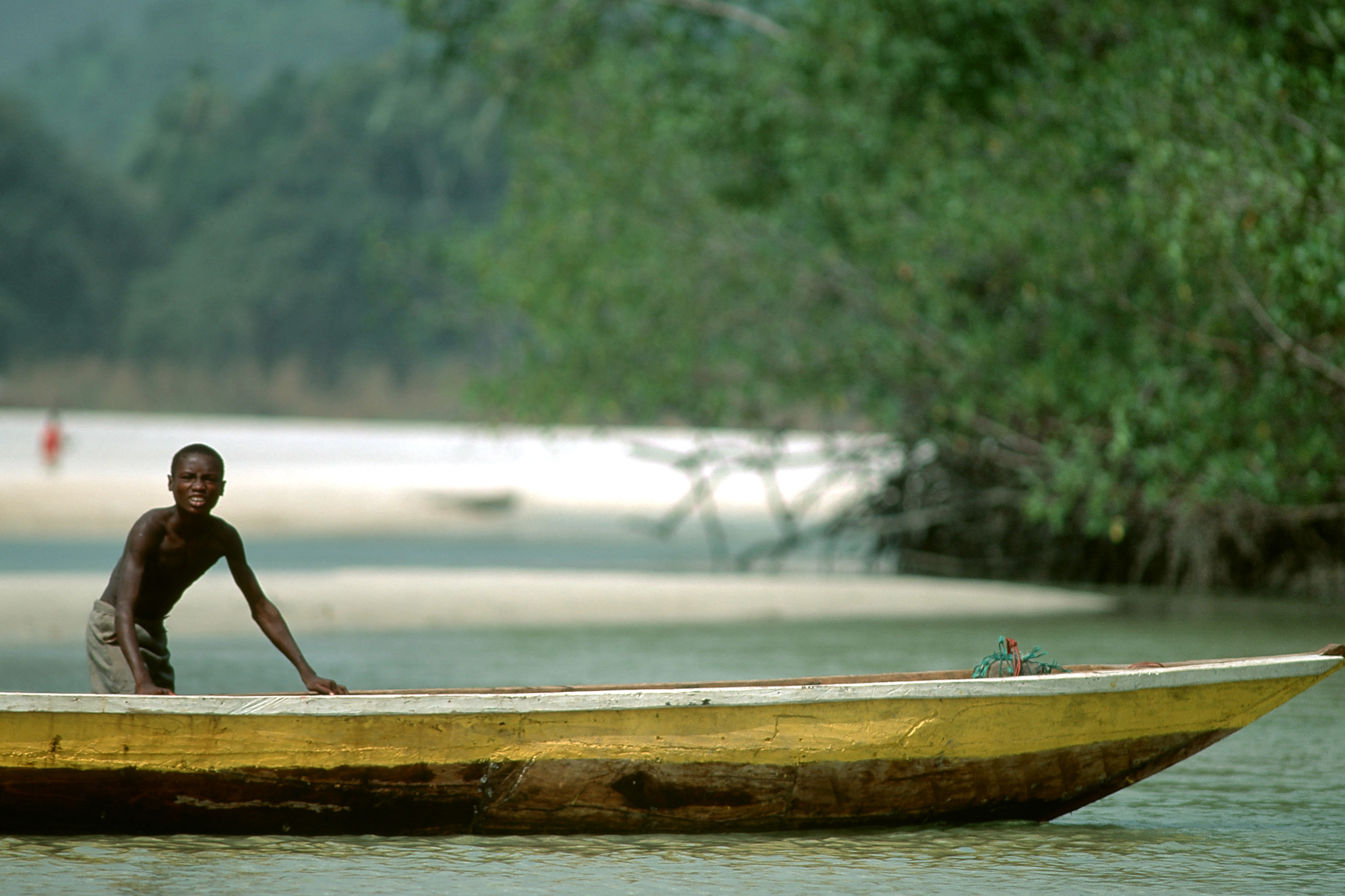 Boy fishing on canoe, Sierra Leone